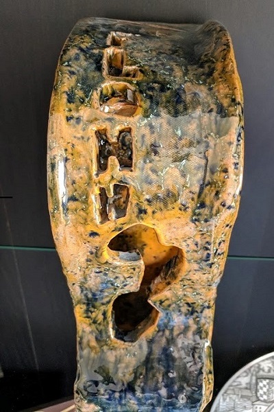 Front view of a ceramic piece in the shape of a 3-dimensional F