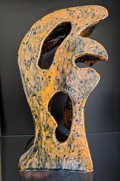 Side view of a ceramic piece in the shape of a 3-dimensional F